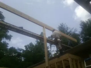 Carpenter setting a ridge beam over a new addition frame — Ice Dam Removal by Roofing Brothers in Fairfield